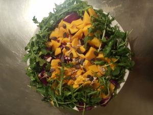 Light salad with rucula, red cabbage, mango, pumpkin seeds and pipes   