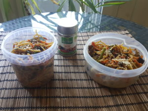 Asian wok tupperwares with vegetables, Judas ears mushrooms, yellow lentils spaghetti. Topping : white sesame